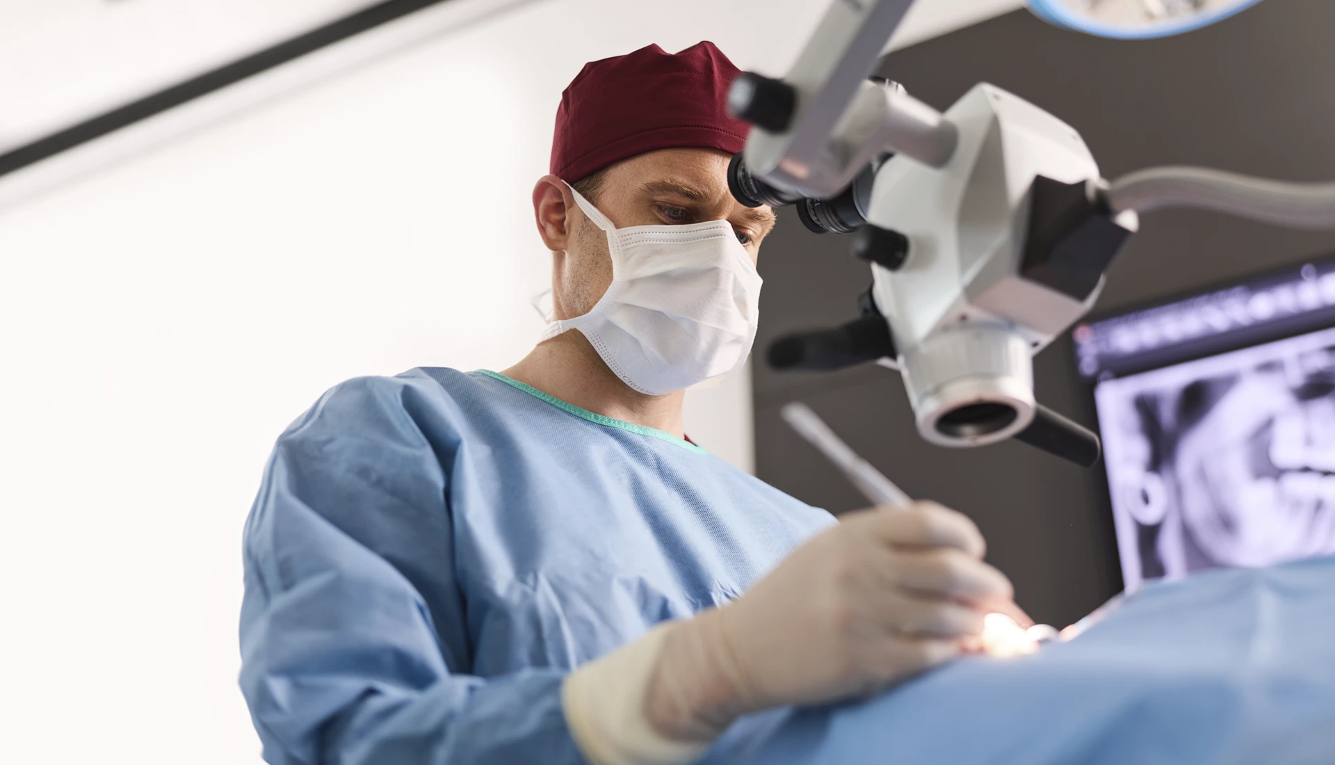 Fachzahnarzt Philipp Deuringer in Behandlung mit Dentalmikroskop.